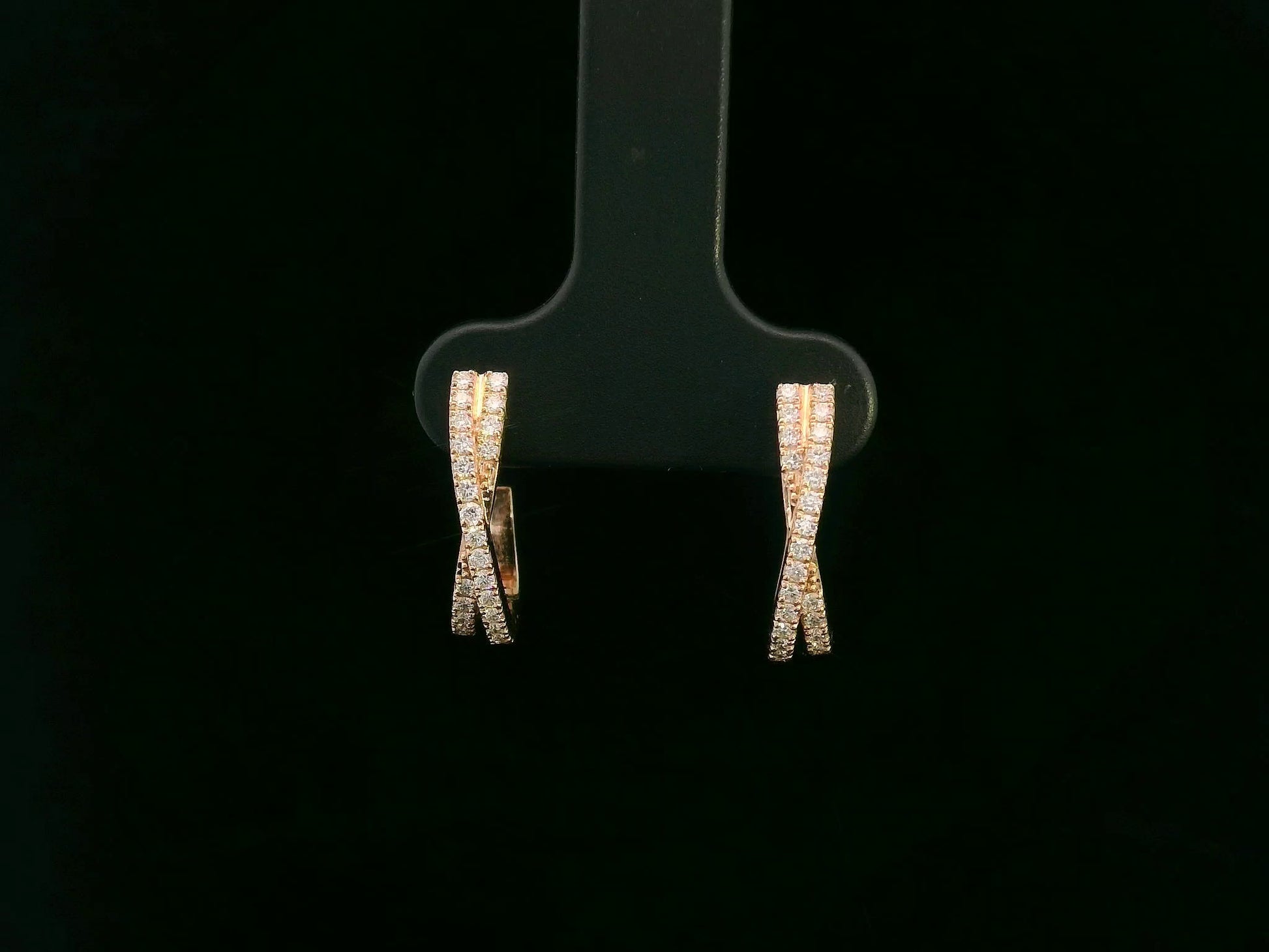 Pair of diamond earrings on a black earring stand