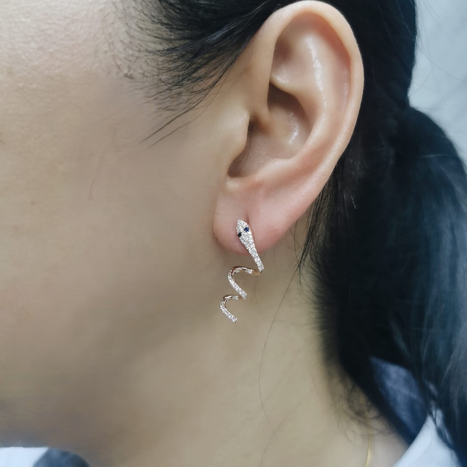 Bold serpent silhouette earrings with gemstone eyes and fluid form