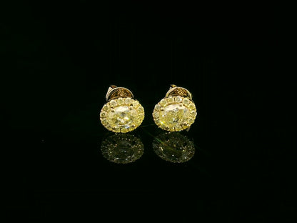 Front view of yellow gold earrings with sparkling fancy yellow diamonds