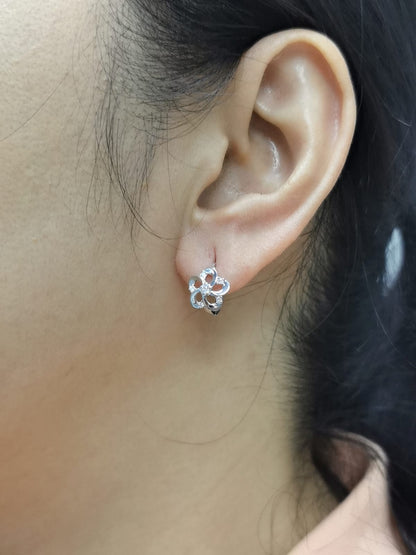 White gold earrings shaped like a flower with diamond accents