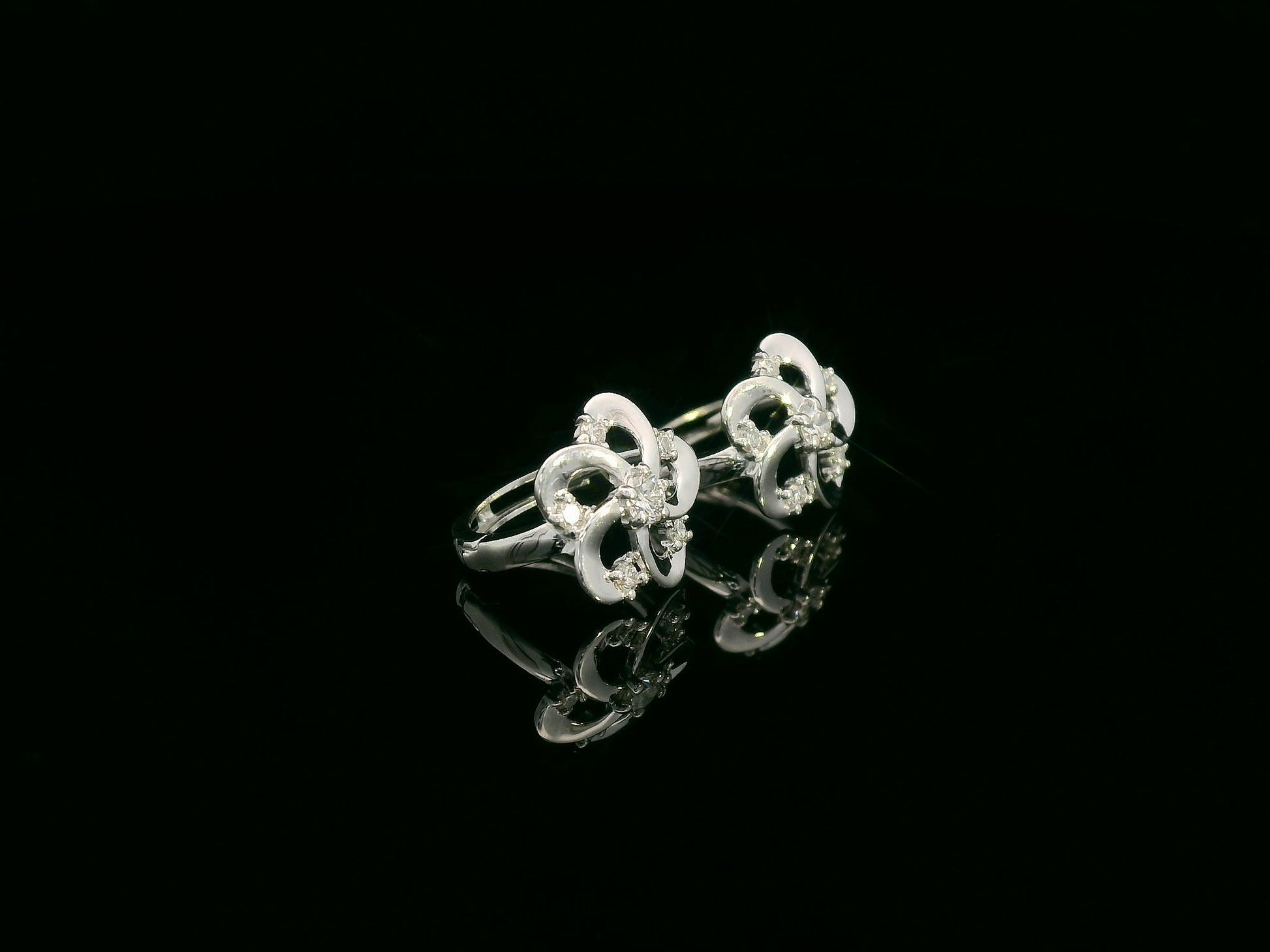 White gold earrings shaped like a flower with diamond accents