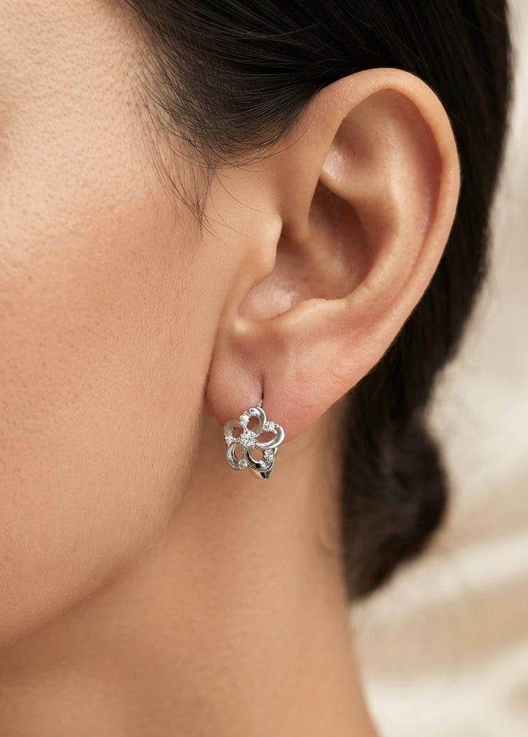Diamond flower huggie earrings in 18K white gold with open floral petals and natural diamond accents
