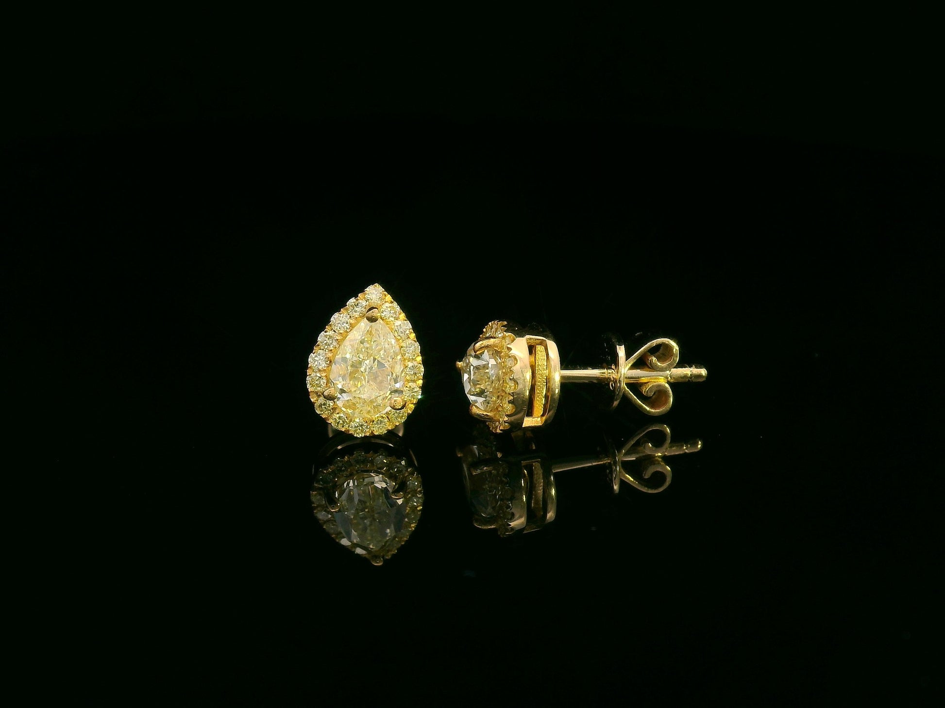 Pear-shaped fancy yellow diamond halo earrings in yellow gold setting