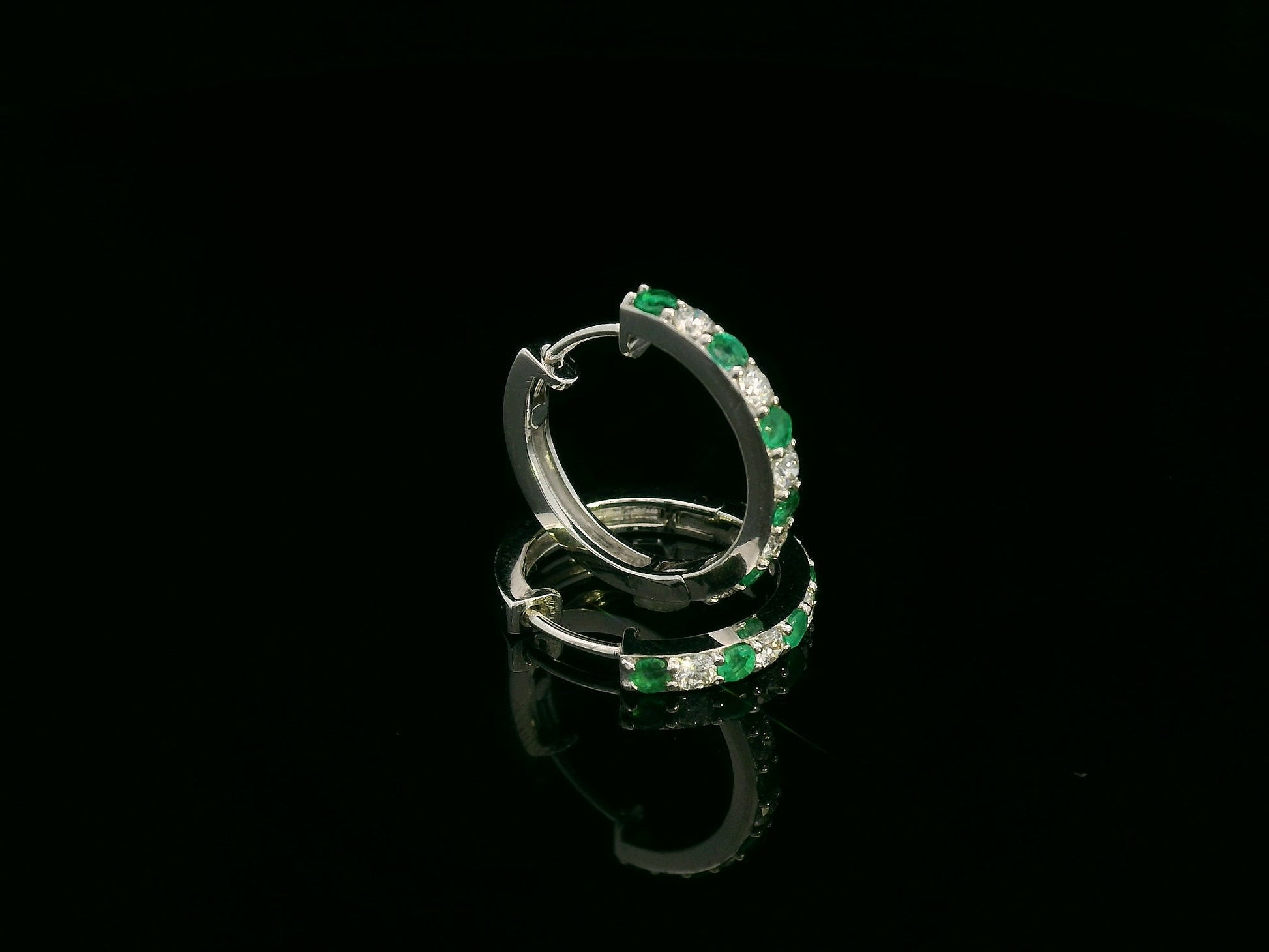 Elegant diamond and emerald gemstone hoop earrings in luxury gift box