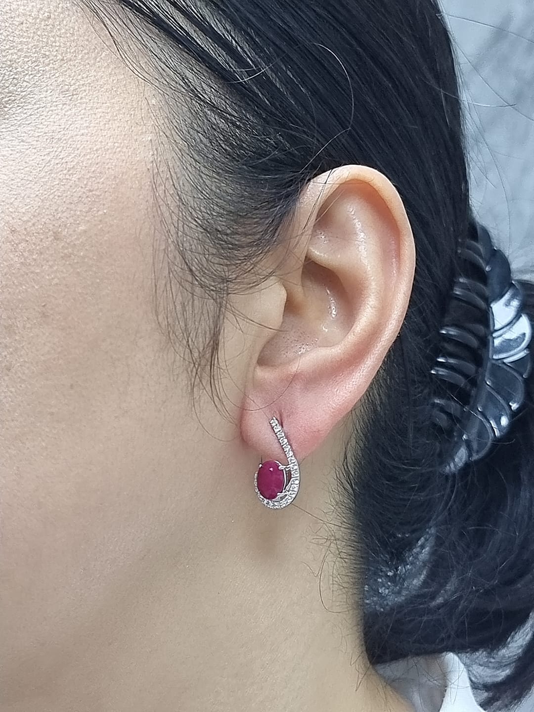 Side profile of 18k white gold ruby and diamond pave curve earrings, showing depth and curved design