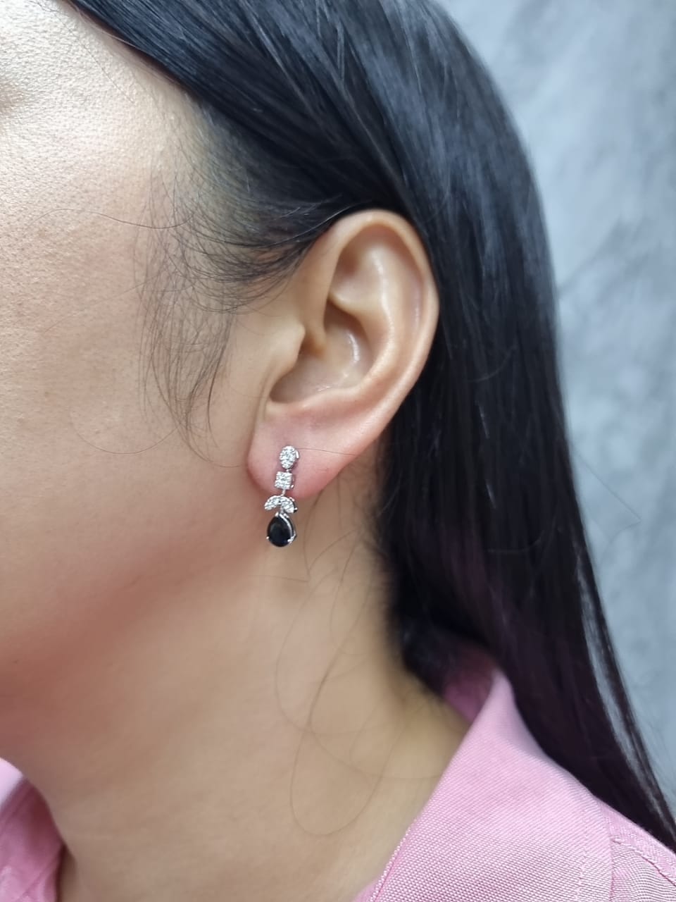 Model wearing 18k gold sapphire and diamond drop earrings with pear-cut sapphires and sparkling diamond clusters