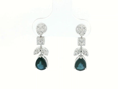 Front view of 18k gold drop earrings with pear-cut blue sapphires and diamond clusters in mixed-shape design