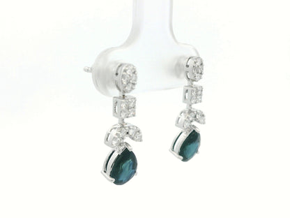 Side profile of 18k gold sapphire and diamond drop earrings showing mixed-shape cluster leading to pear-cut sapphire
