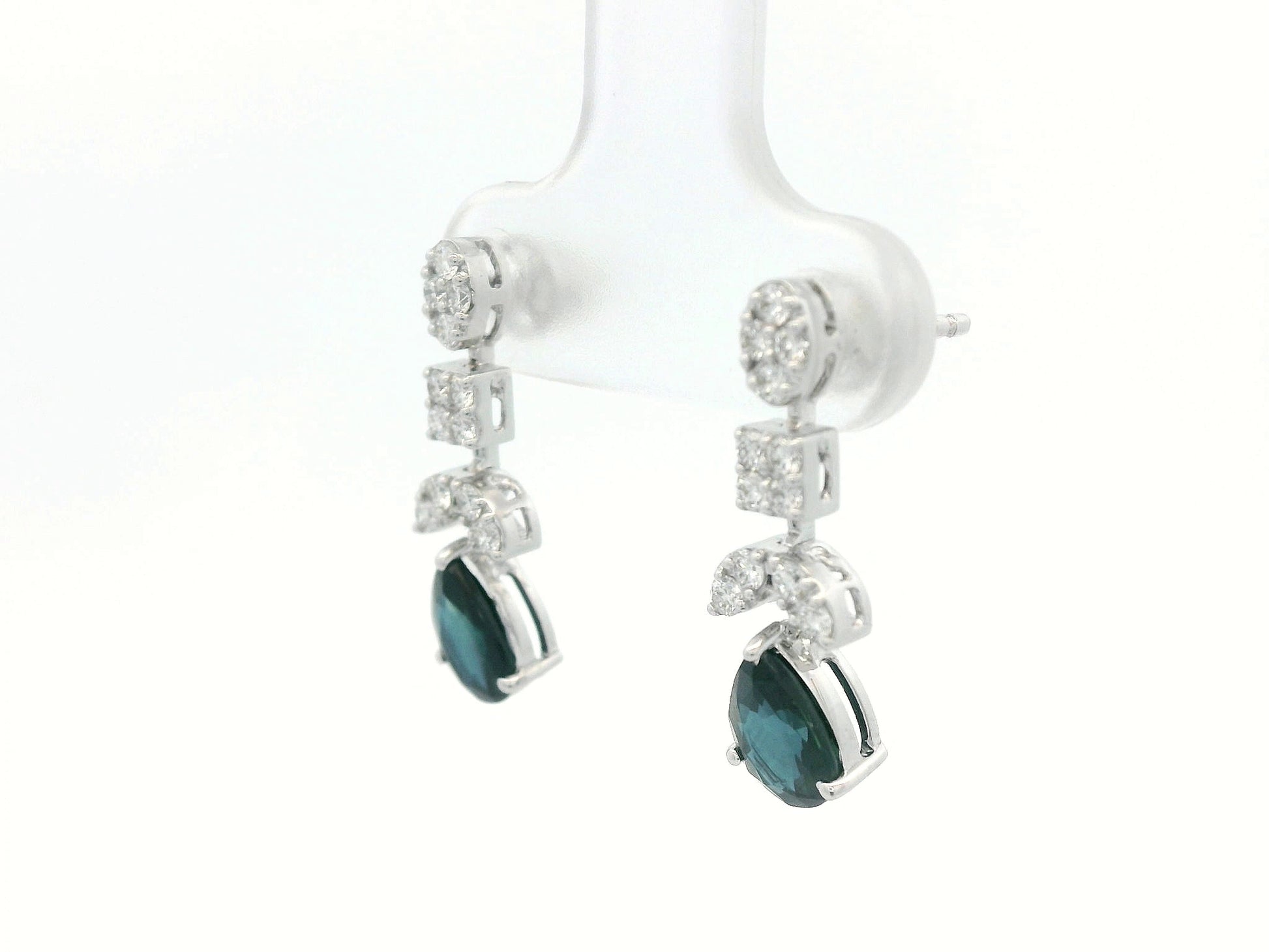 Side profile of 18k gold sapphire and diamond drop earrings showing mixed-shape cluster leading to pear-cut sapphire