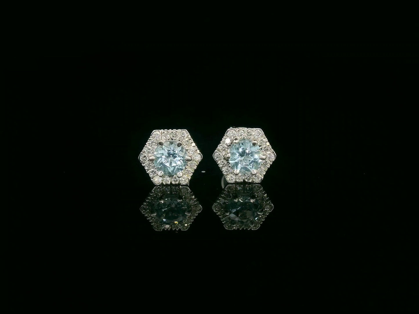 Front view of 18k gold stud earrings with round aquamarines and diamond halo
