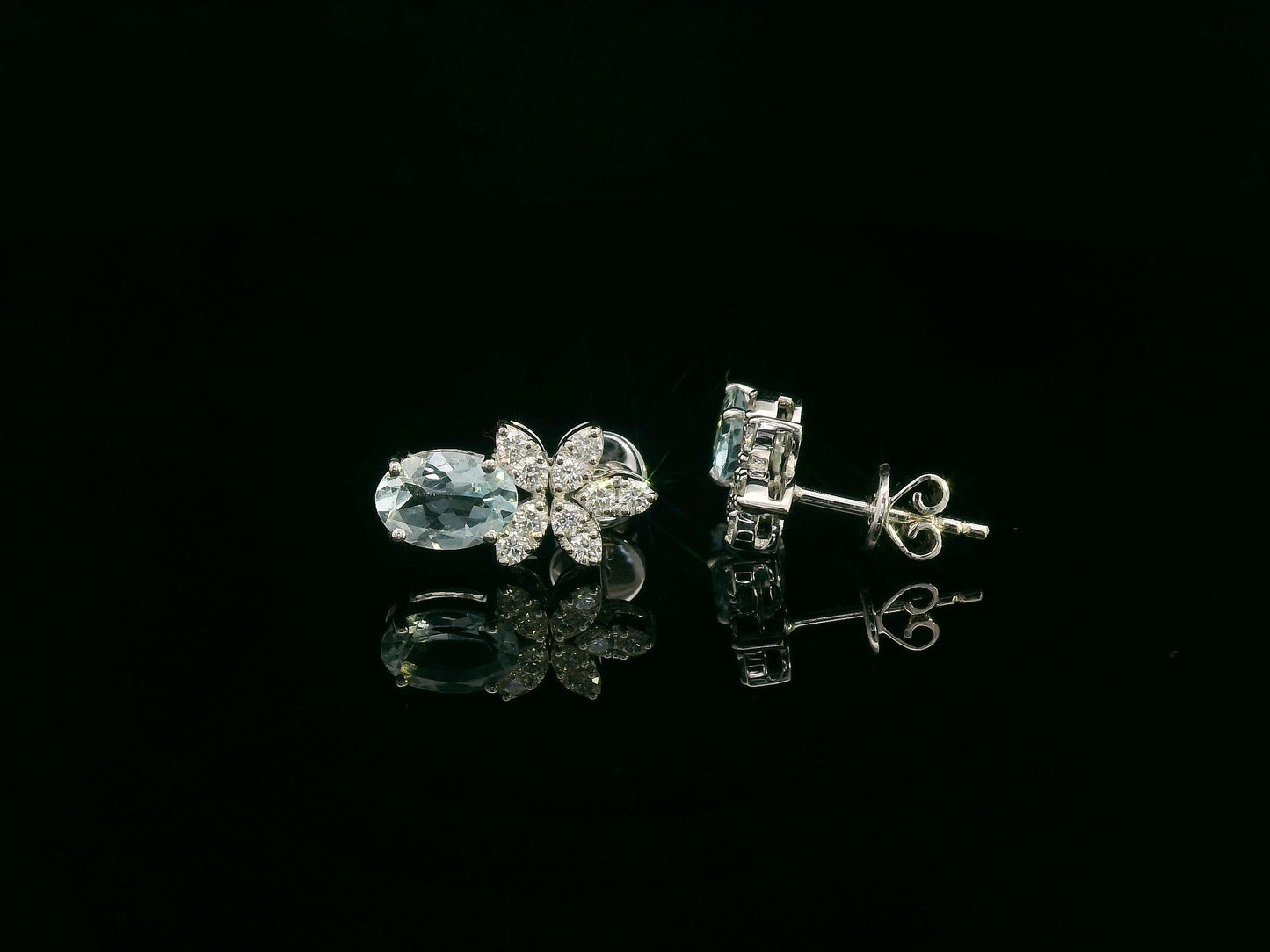 Front view of 18k gold drop earrings with oval aquamarines and floral diamond cluster