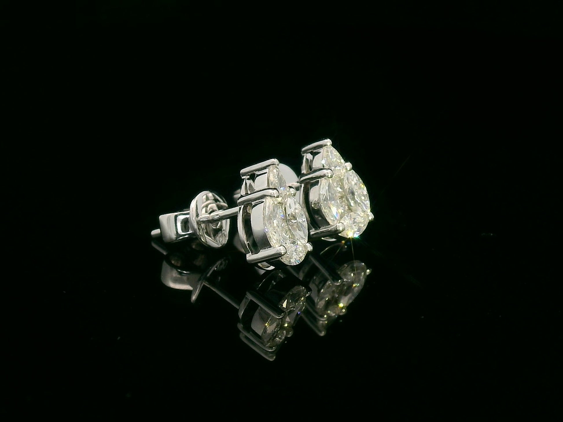 side view of 18k white gold stud earrings with pear, marquise, and princess-cut diamond cluster