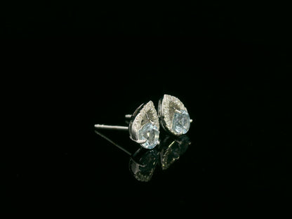 18K white gold earrings featuring 0.49ct round-cut aquamarine with 0.08ct diamond teardrop accent on one side of each stone.