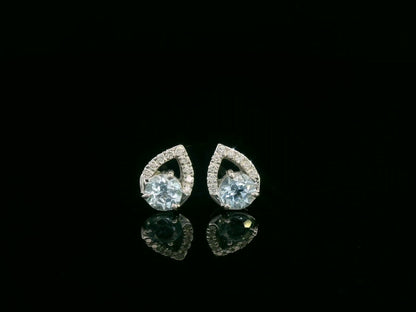 18K white gold earrings featuring 0.49ct round-cut aquamarine with 0.08ct diamond teardrop accent on one side of each stone.
