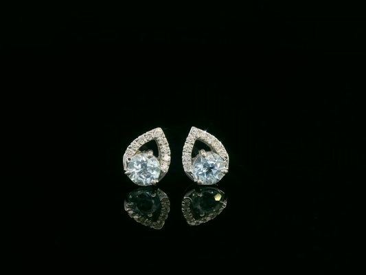 18K white gold earrings featuring 0.49ct round-cut aquamarine with 0.08ct diamond teardrop accent on one side of each stone.