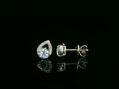 18K white gold earrings featuring 0.49ct round-cut aquamarine with 0.08ct diamond teardrop accent on one side of each stone.