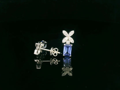 18K white gold earrings featuring emerald-cut Tanzanites beneath floral diamond clusters, total 1.56 carat