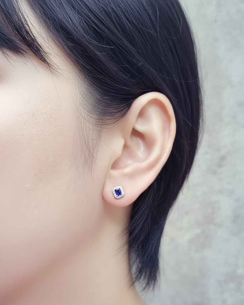 Minimalist 18K white gold halo stud earrings with emerald-cut blue sapphires and diamond accents 