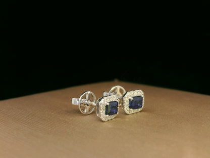 Minimalist 18K white gold halo stud earrings with emerald-cut blue sapphires and diamond accents 