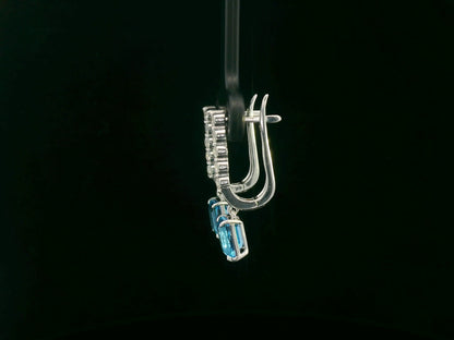 18K white gold dangle earrings with 2.32 ct emerald-cut blue topaz and 0.58 ct round diamonds