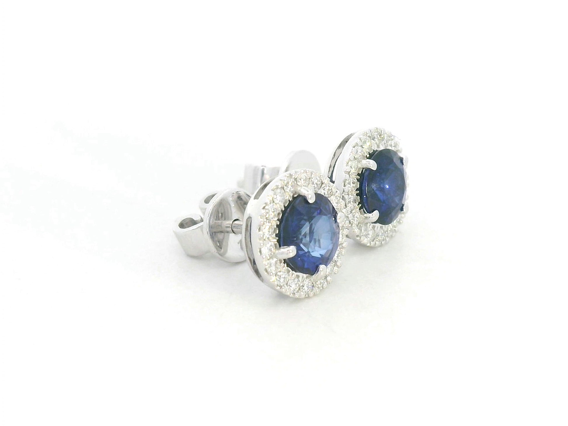 18K white gold blue sapphire and diamond halo stud earrings with round sapphires, 1.40 carat sapphires and 0.20 carat diamonds by Emirates Diamonds