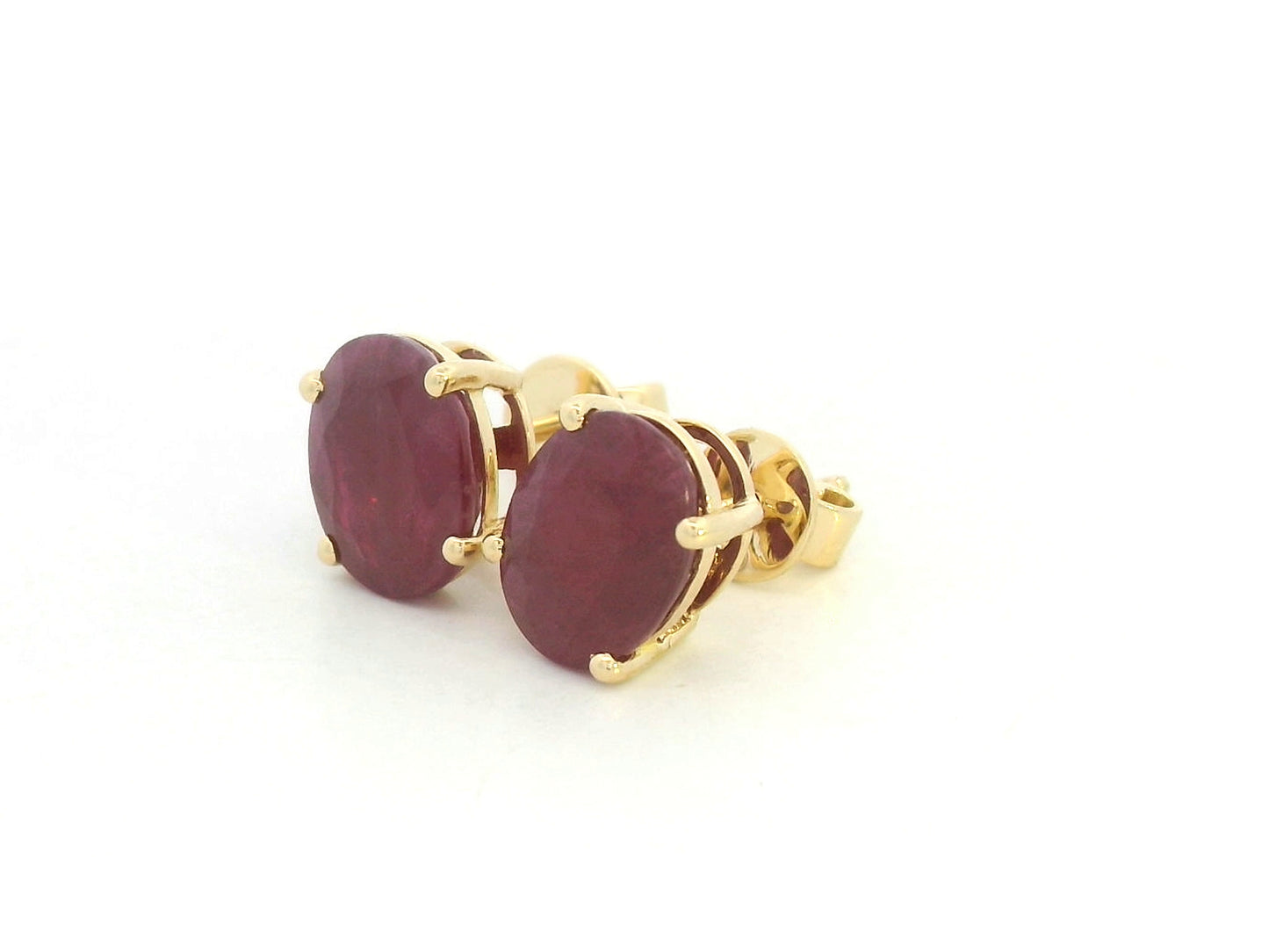18K yellow gold ruby stud earrings featuring oval-cut natural rubies totaling 5.19 carats by Emirates Diamonds.