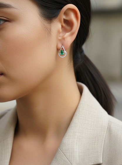 Emerald and diamond stud earrings in 18K white gold with pear-cut emeralds and pavé diamond accents by Emirates Diamonds