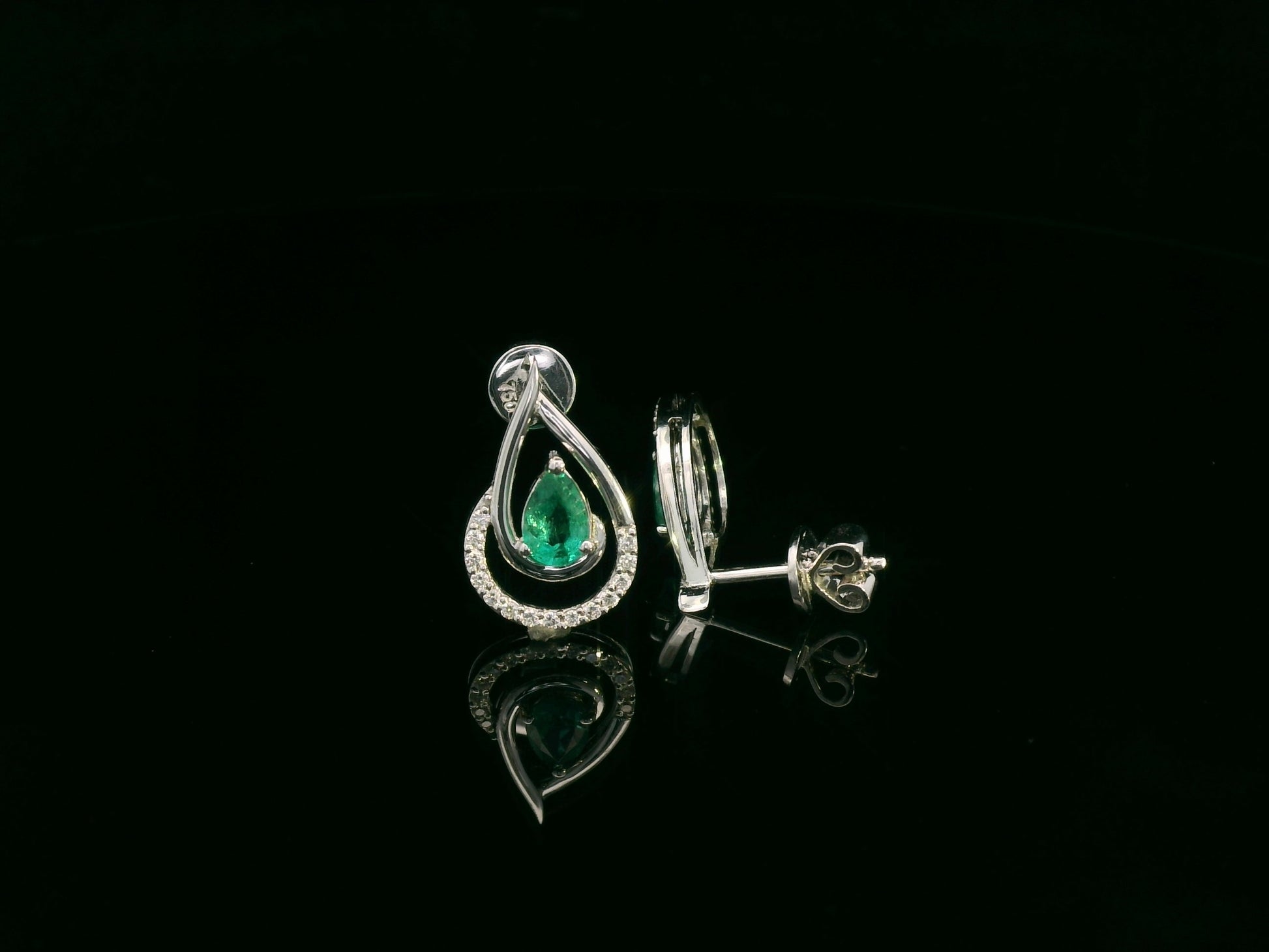Emerald and diamond stud earrings in 18K white gold with pear-cut emeralds and pavé diamond accents by Emirates Diamonds
