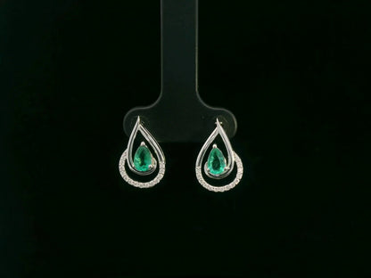 Emerald and diamond stud earrings in 18K white gold with pear-cut emeralds and pavé diamond accents by Emirates Diamonds