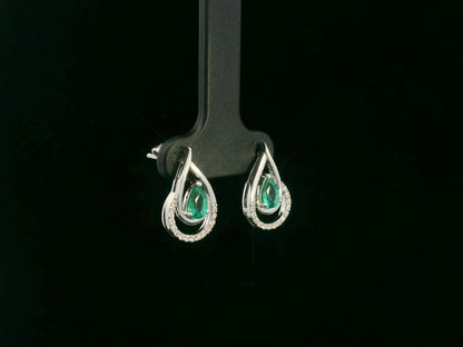 Emerald and diamond stud earrings in 18K white gold with pear-cut emeralds and pavé diamond accents by Emirates Diamonds