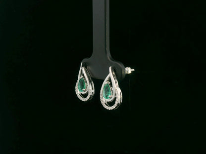 Emerald and diamond stud earrings in 18K white gold with pear-cut emeralds and pavé diamond accents by Emirates Diamonds