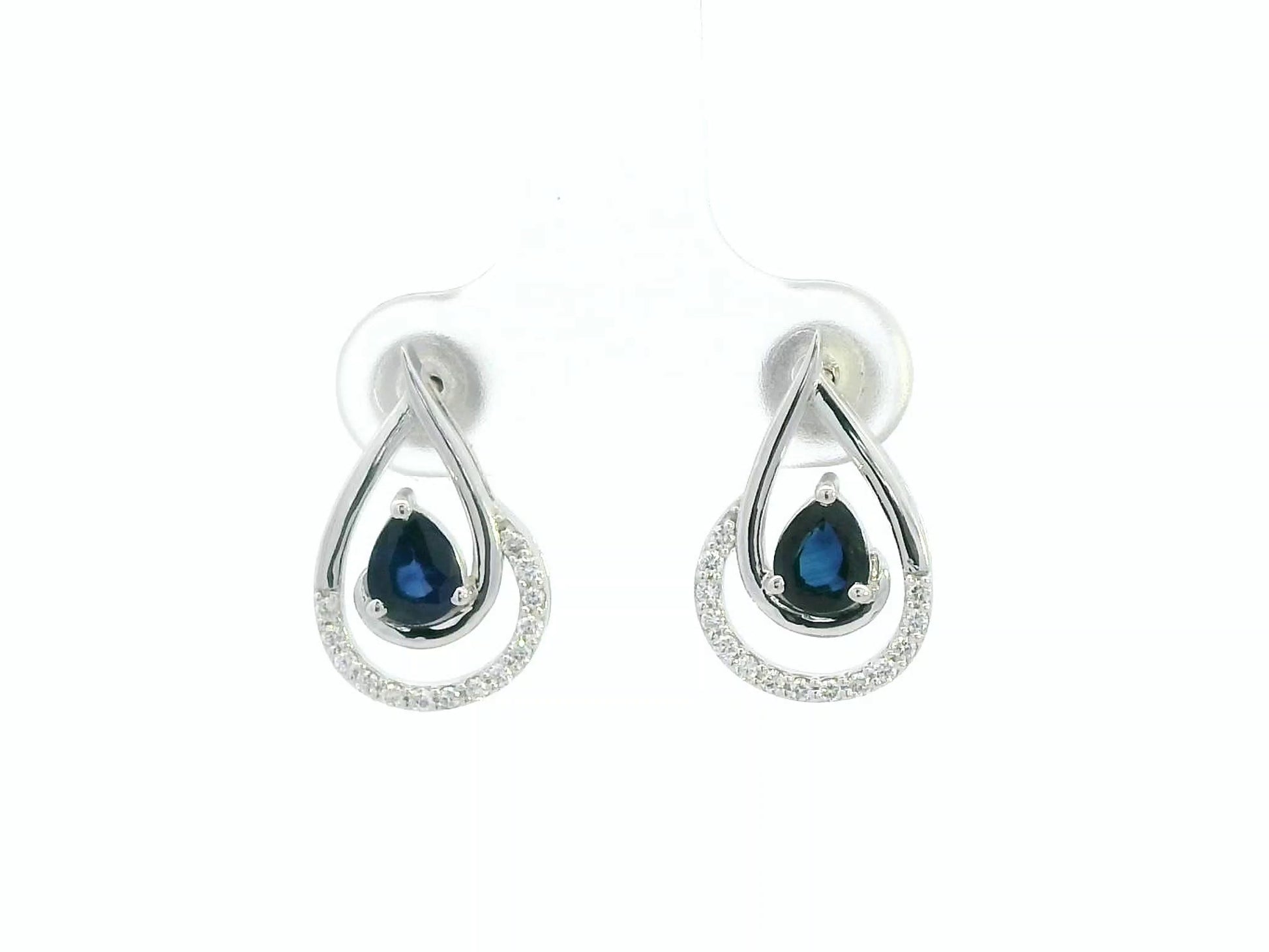 Blue sapphire and diamond stud earrings in 18K white gold with pear-cut sapphires and pavé diamond accents by Emirates Diamonds