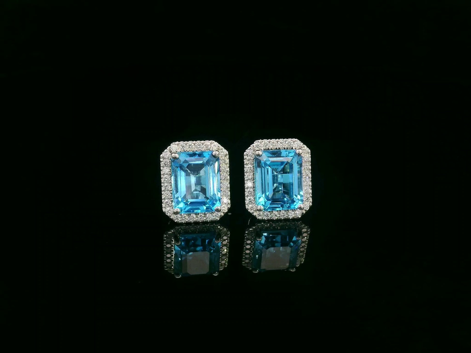 Swiss blue topaz and diamond stud earrings in 18K white gold with emerald-cut topaz and diamond halo by Emirates Diamonds