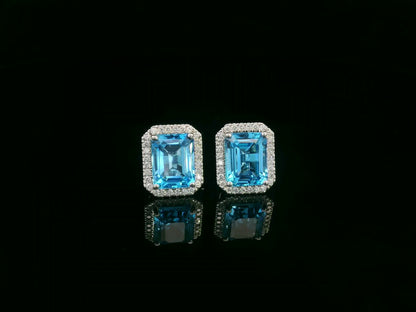 Swiss blue topaz and diamond stud earrings in 18K white gold with emerald-cut topaz and diamond halo by Emirates Diamonds