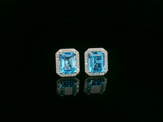 Swiss blue topaz and diamond stud earrings in 18K white gold with emerald-cut topaz and diamond halo by Emirates Diamonds