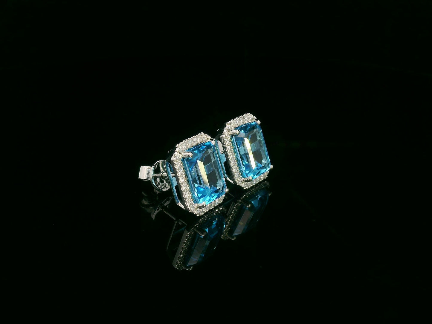 Swiss blue topaz and diamond stud earrings in 18K white gold with emerald-cut topaz and diamond halo by Emirates Diamonds