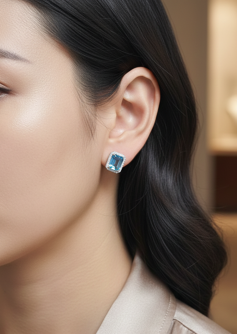 Swiss blue topaz and diamond stud earrings in 18K white gold with emerald-cut topaz and diamond halo by Emirates Diamonds