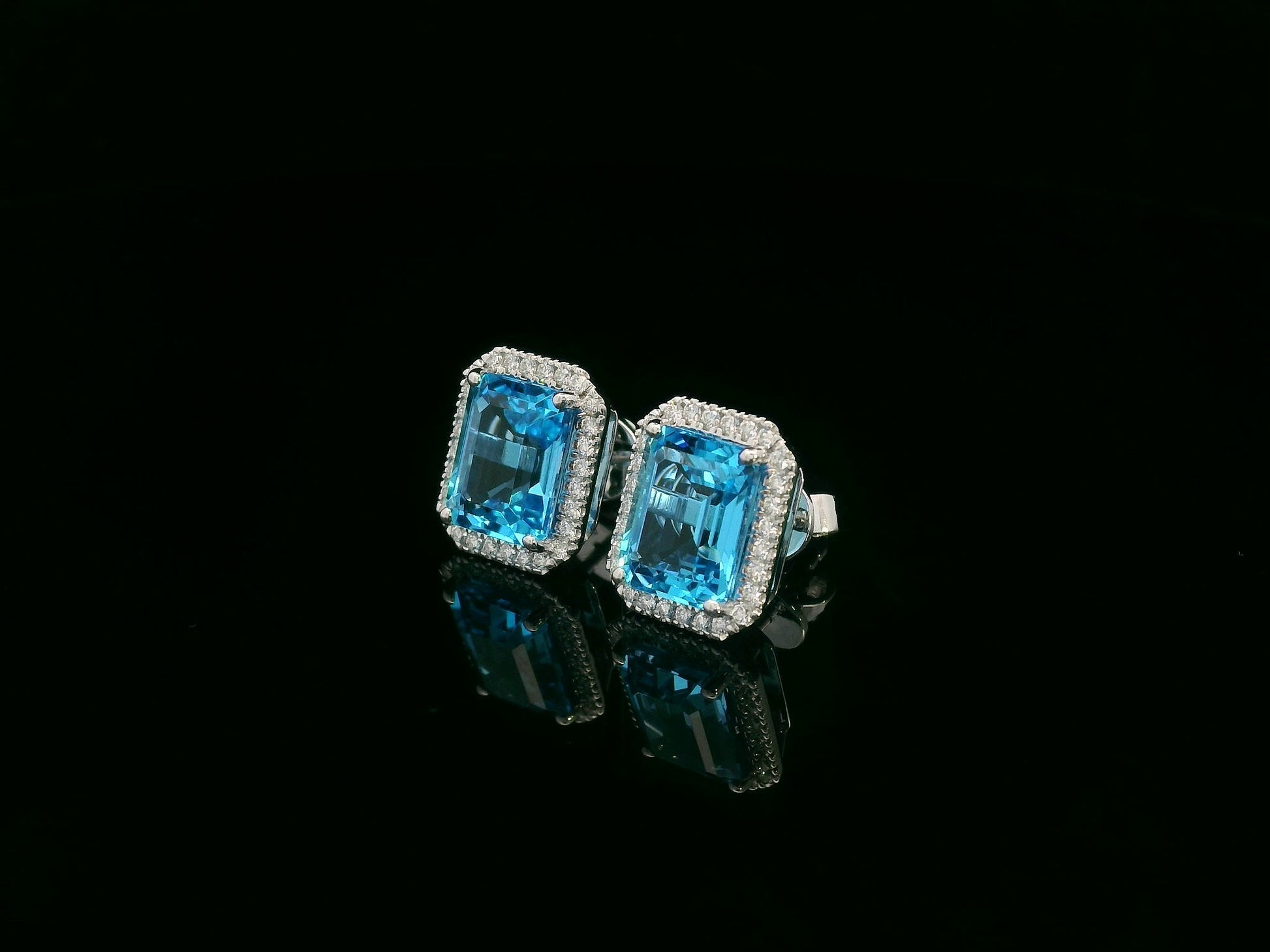 Swiss blue topaz and diamond stud earrings in 18K white gold with emerald-cut topaz and diamond halo by Emirates Diamonds