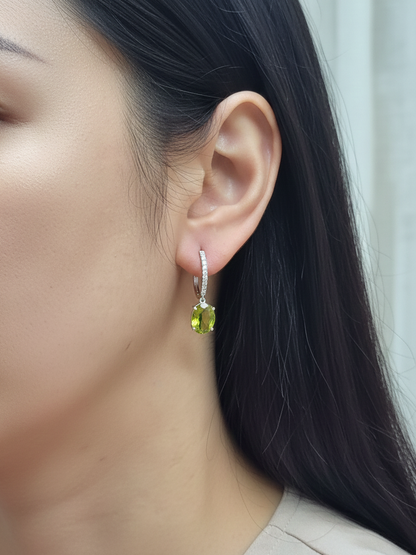 Peridot and diamond drop hoop earrings in 18K white gold with oval-cut peridots totaling 4.86 carats by Emirates Diamonds