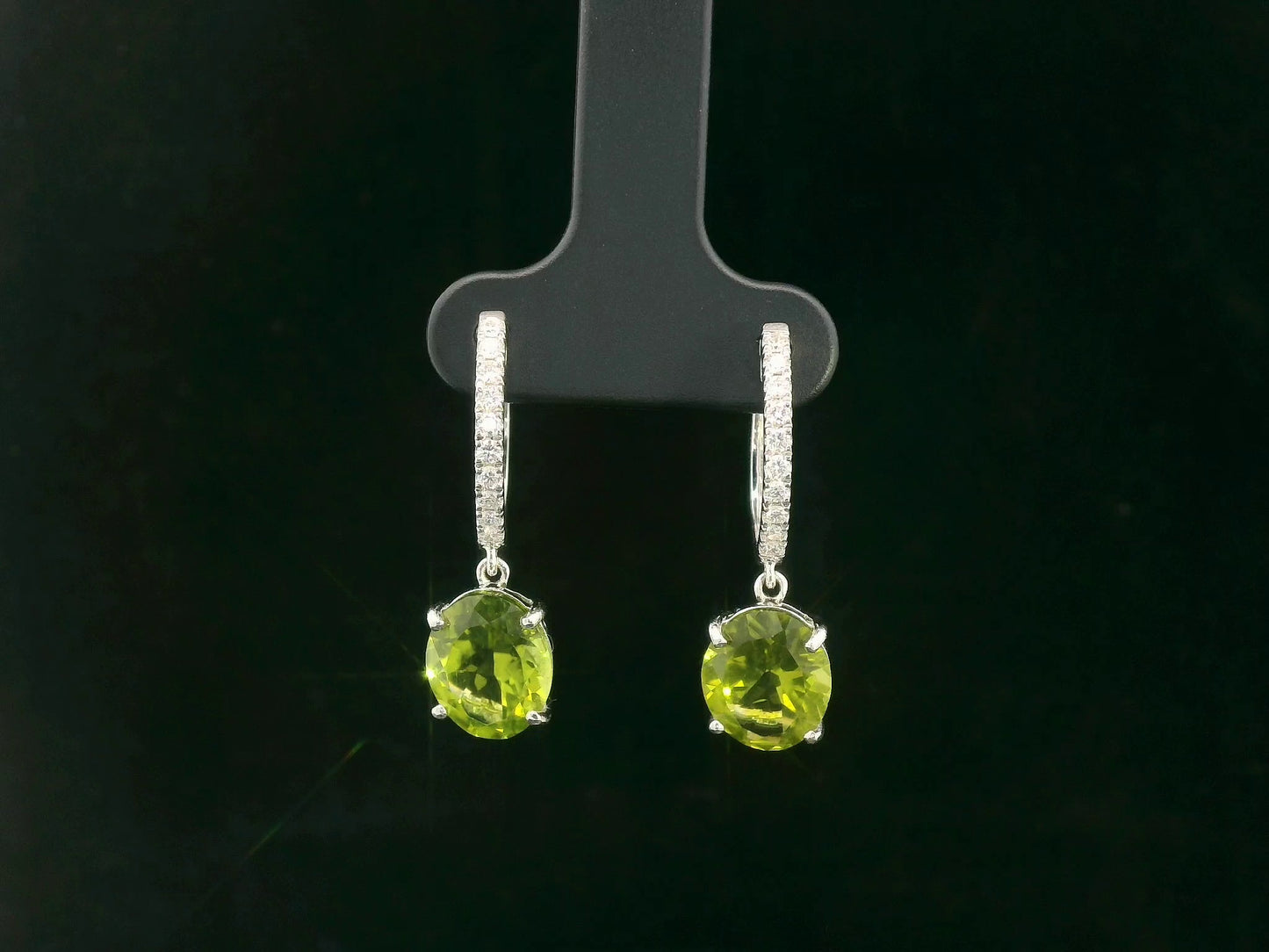 Peridot and diamond drop hoop earrings in 18K white gold with oval-cut peridots totaling 4.86 carats by Emirates Diamonds