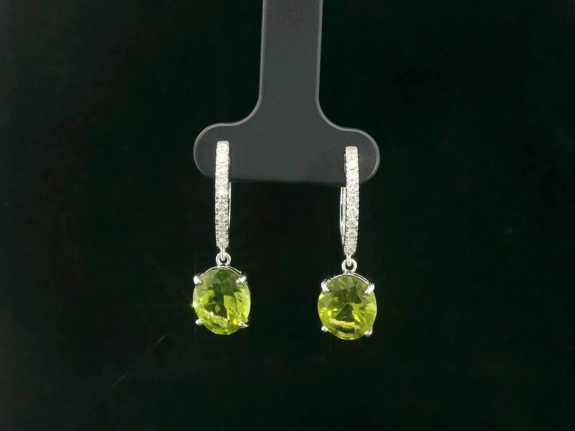 Peridot and diamond drop hoop earrings in 18K white gold with oval-cut peridots totaling 4.86 carats by Emirates Diamonds