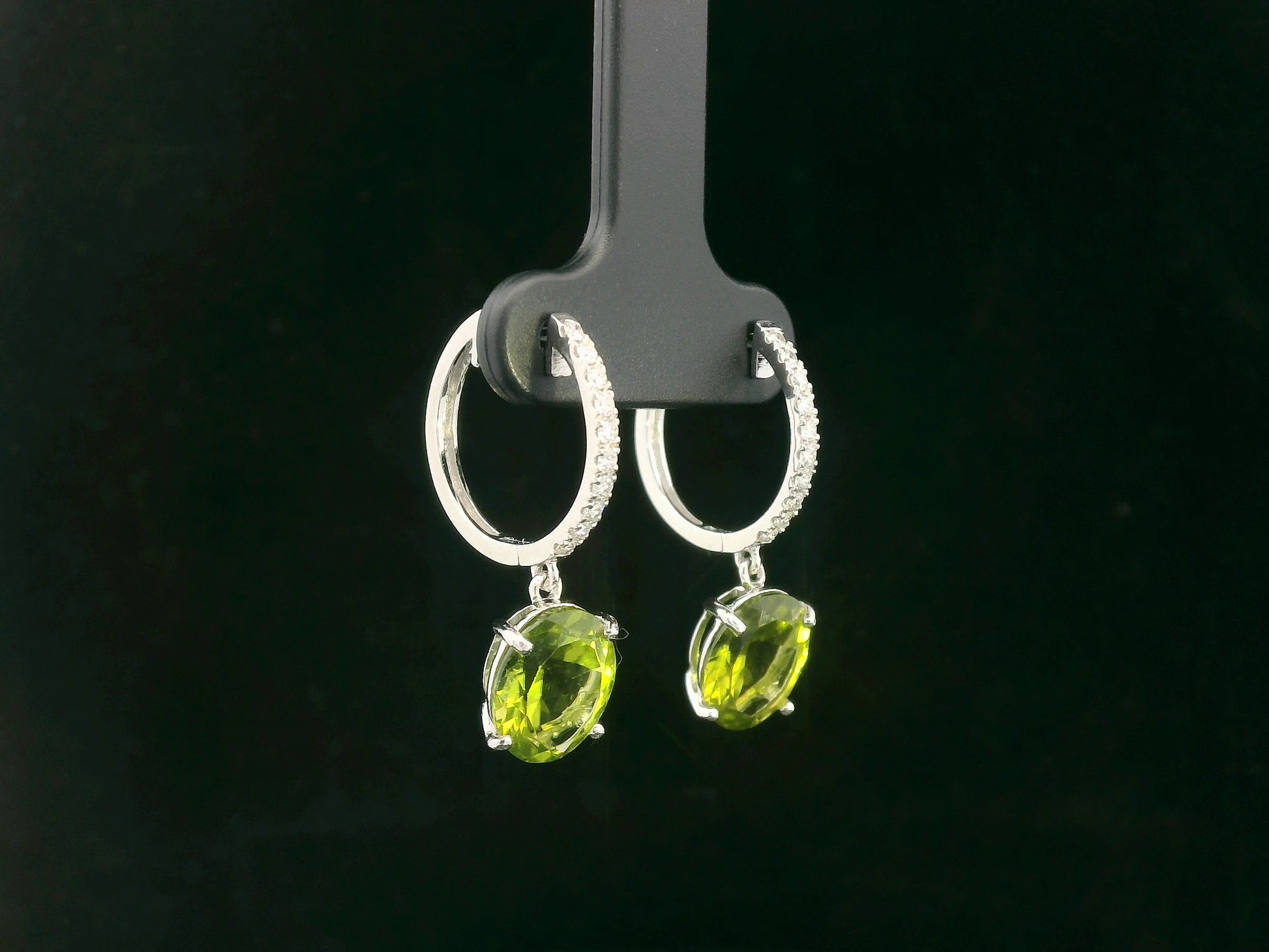 Peridot and diamond drop hoop earrings in 18K white gold with oval-cut peridots totaling 4.86 carats by Emirates Diamonds