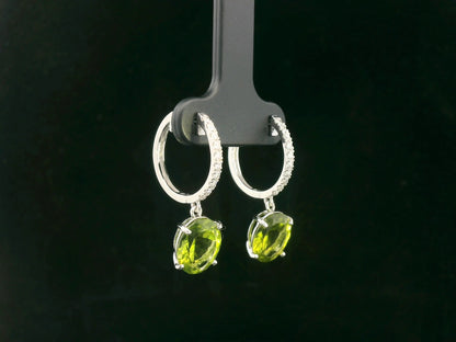 Peridot and diamond drop hoop earrings in 18K white gold with oval-cut peridots totaling 4.86 carats by Emirates Diamonds