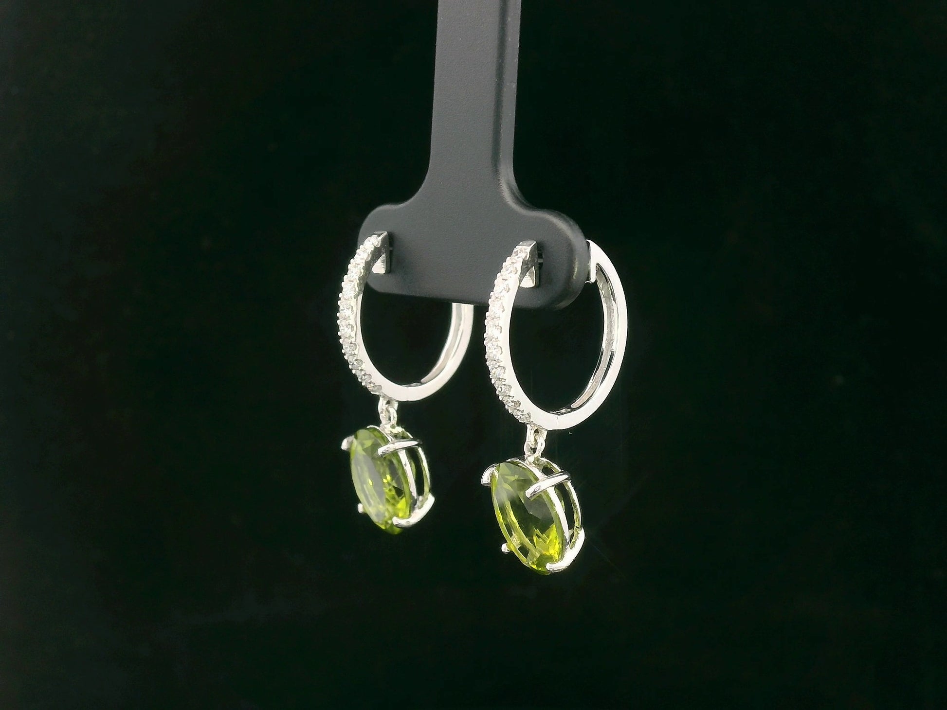 Peridot and diamond drop hoop earrings in 18K white gold with oval-cut peridots totaling 4.86 carats by Emirates Diamonds