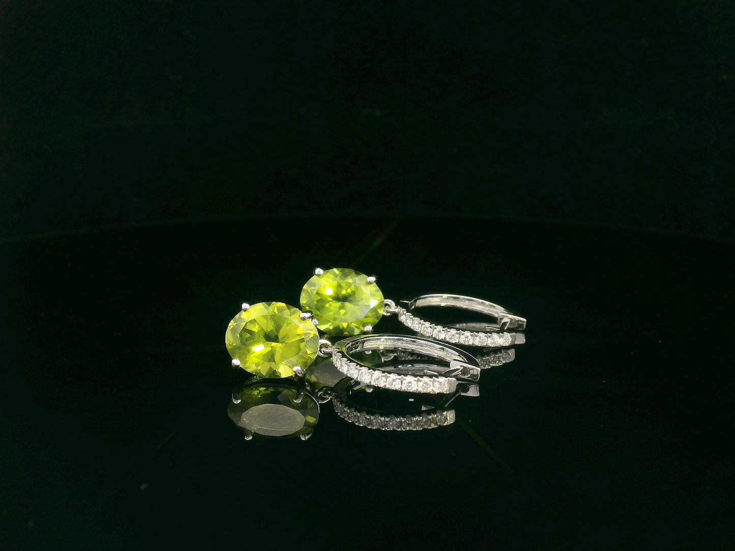 Peridot and diamond drop hoop earrings in 18K white gold with oval-cut peridots totaling 4.86 carats by Emirates Diamonds