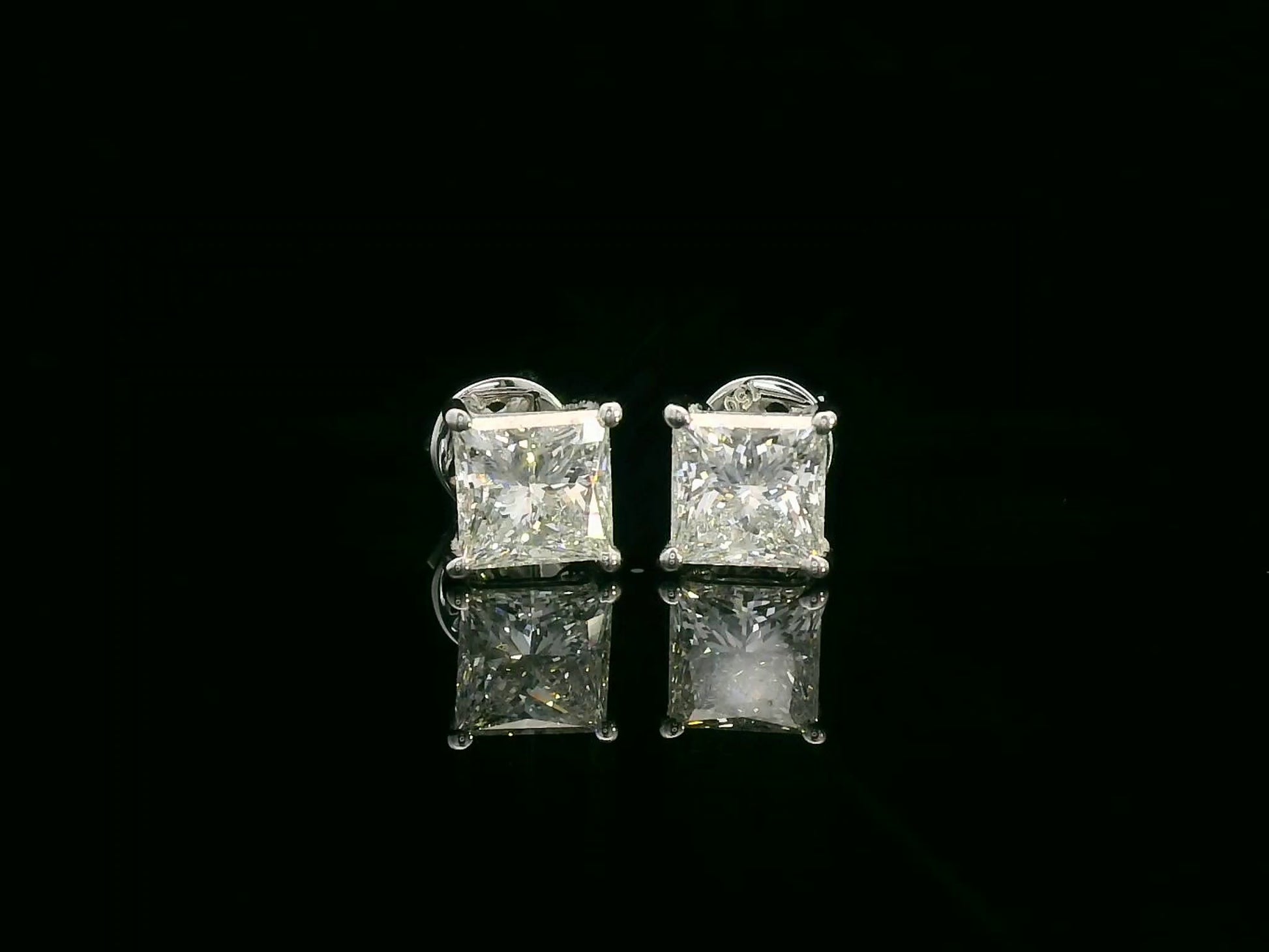 Princess cut diamond solitaire stud earrings in 18K white gold featuring 2.02 carats total GIA certified VS2 F color diamonds by Emirates Diamonds