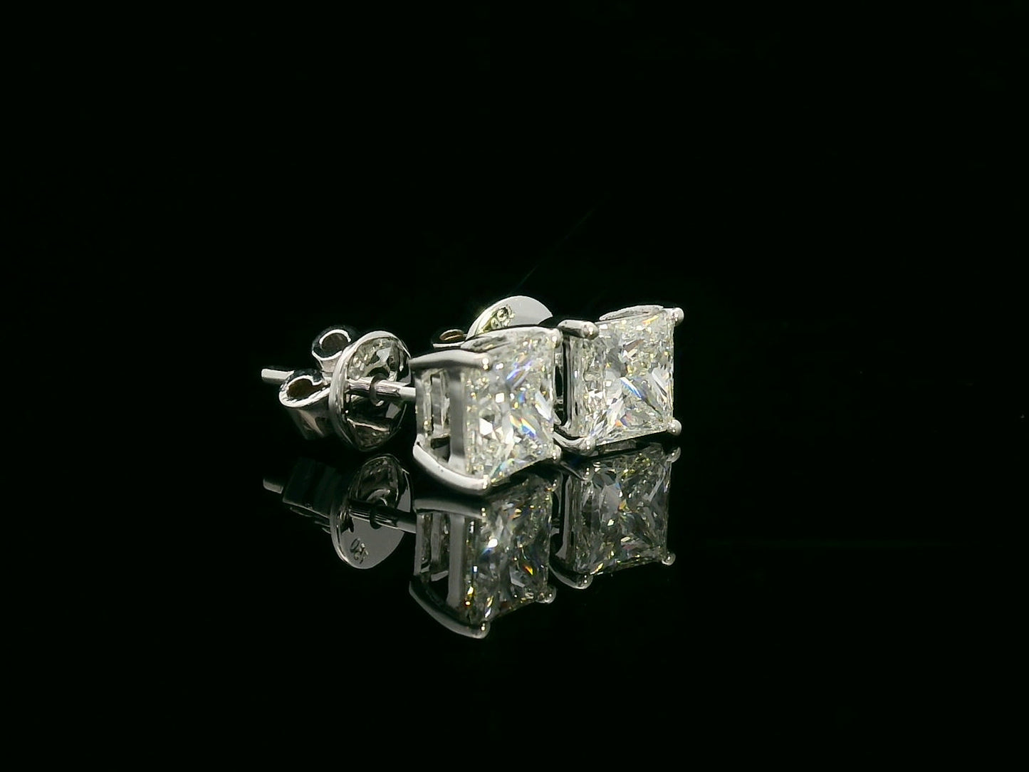 Princess cut diamond solitaire stud earrings in 18K white gold featuring 2.02 carats total GIA certified VS2 F color diamonds by Emirates Diamonds