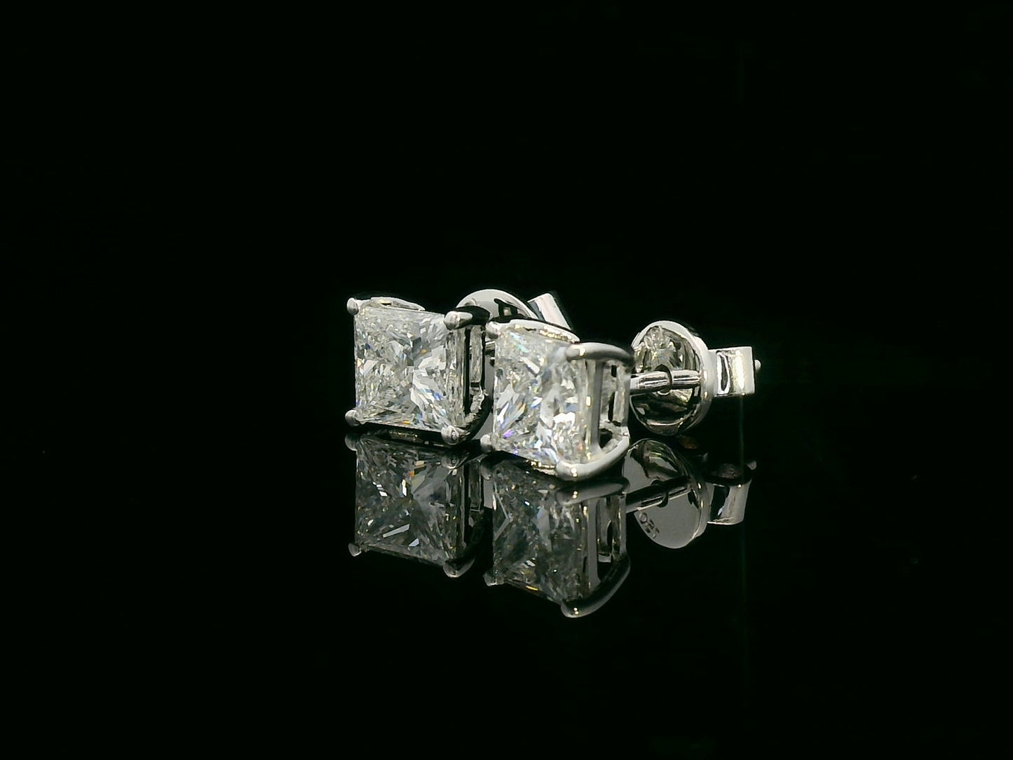 Princess cut diamond solitaire stud earrings in 18K white gold featuring 2.02 carats total GIA certified VS2 F color diamonds by Emirates Diamonds