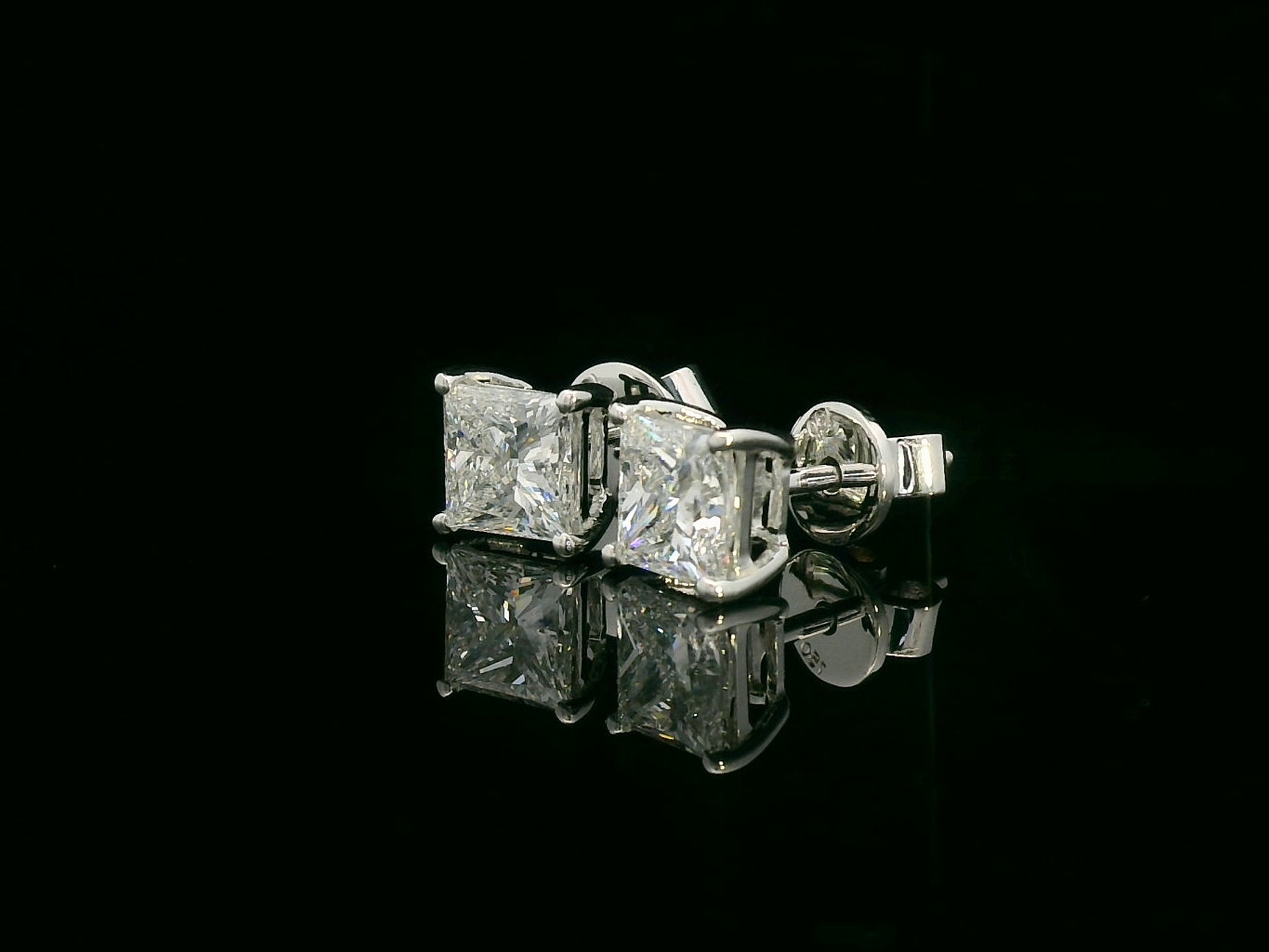 Princess cut diamond solitaire stud earrings in 18K white gold featuring 2.02 carats total GIA certified VS2 F color diamonds by Emirates Diamonds