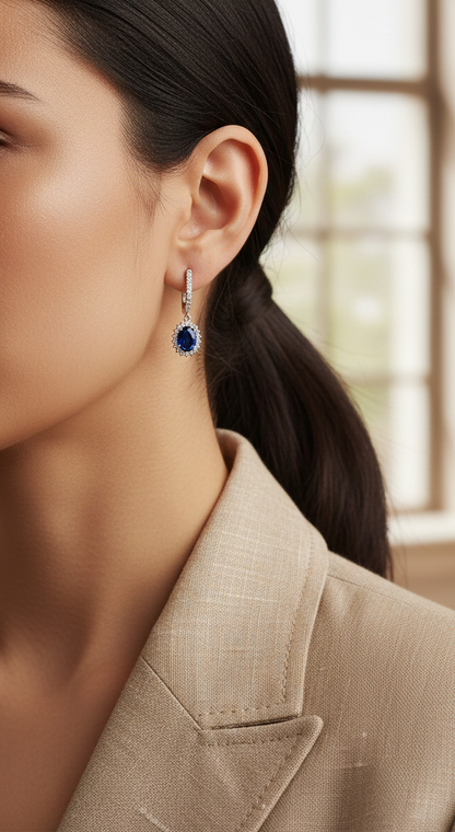 18K white gold sapphire and diamond drop earrings with oval sapphire halos by Emirates Diamonds